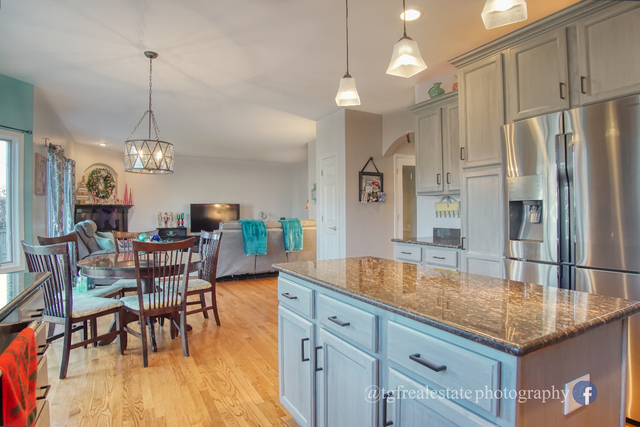 S643 Robbins Street Winfield, IL 60190 - Photo 8 of 40 a kitchen with stainless steel appliances granite countertop a kitchen island a stove a table and chairs