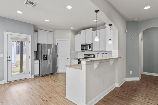 a kitchen with stainless steel appliances a refrigerator sink and microwave