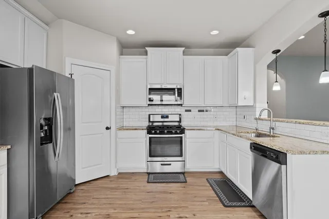 a kitchen with stainless steel appliances granite countertop a refrigerator stove and sink