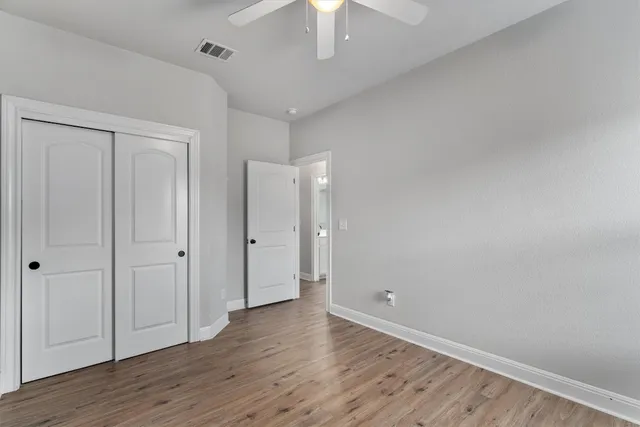 a view of an empty room with wooden floor