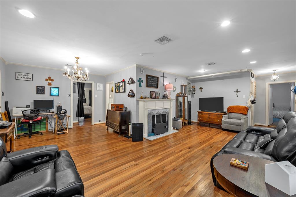 301 North 40th Street Waco, TX 76710 - Photo 5 of 26 Spacious living area featuring wood-finish flooring, a decorative fireplace with mantel, recessed lighting, and a chandelier