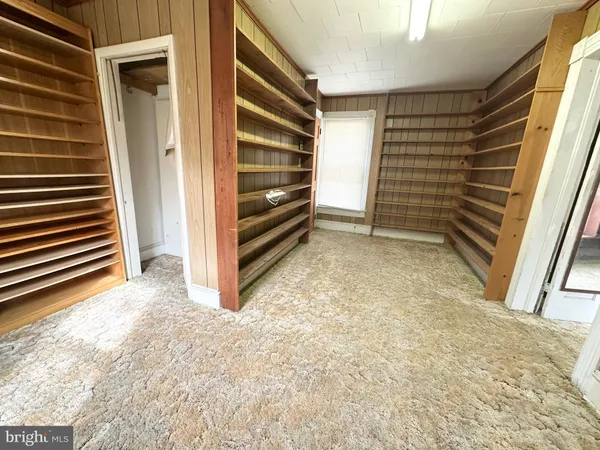 a view of an empty room with stairs and a window