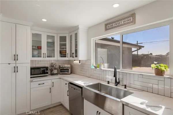 a front view of a building with glass windows and potted plants