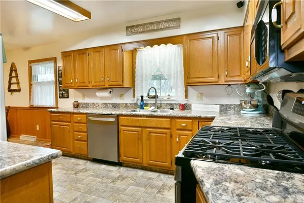 a kitchen with stainless steel appliances granite countertop a stove a sink and a microwave