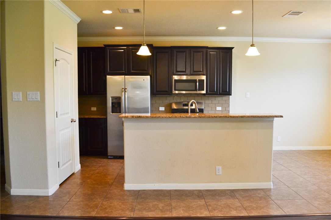 14001 Avery Ranch Boulevard, Unit 2902 Austin, TX 78717 - Photo 2 of 14 a kitchen with kitchen island granite countertop cabinets and refrigerator