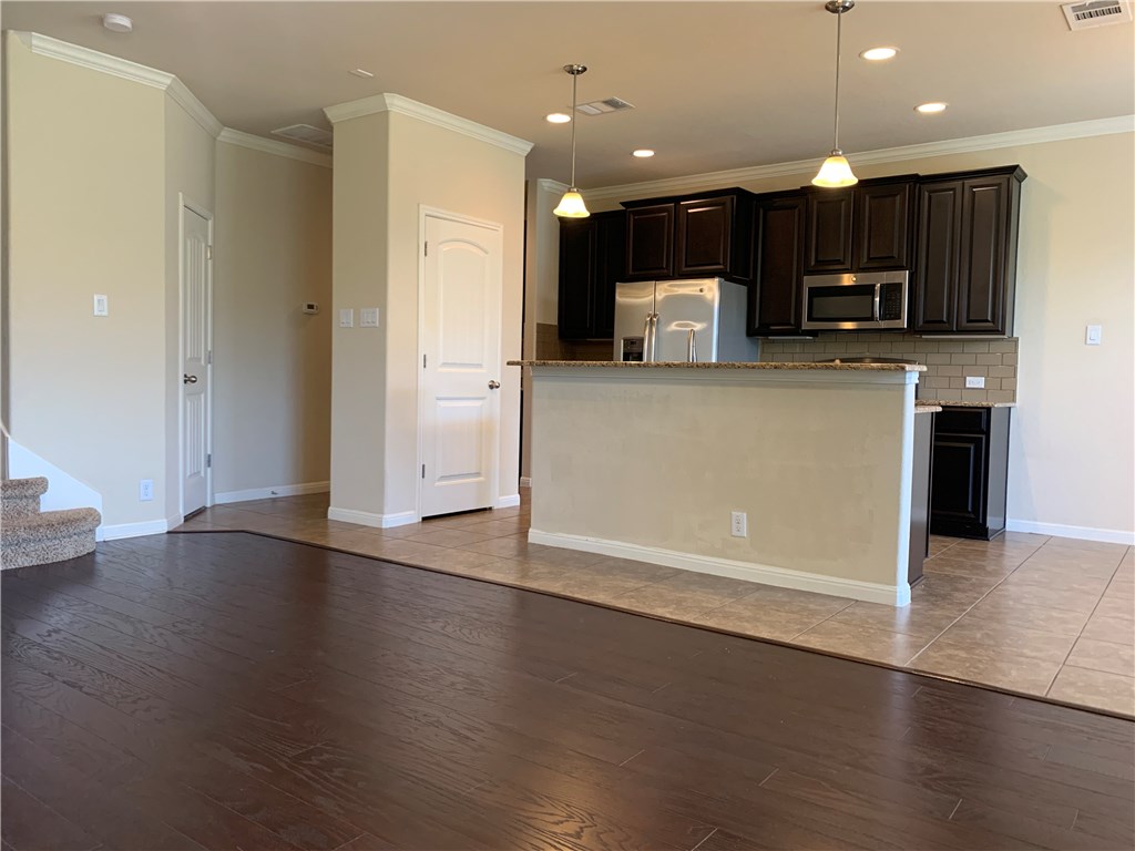 14001 Avery Ranch Boulevard, Unit 2902 Austin, TX 78717 - Photo 5 of 14 an open kitchen with wooden floor and a refrigerator