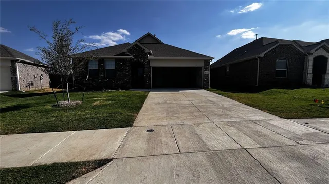 a front view of a house with a yard and a garage