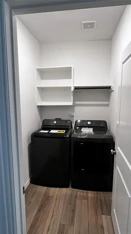 a black car sitting on the side of a wooden floor