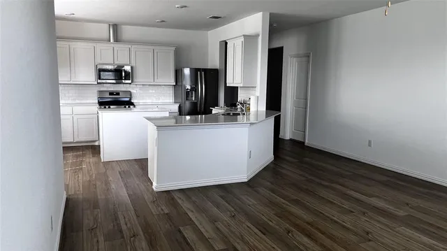 a kitchen with stainless steel appliances a refrigerator and a stove top oven