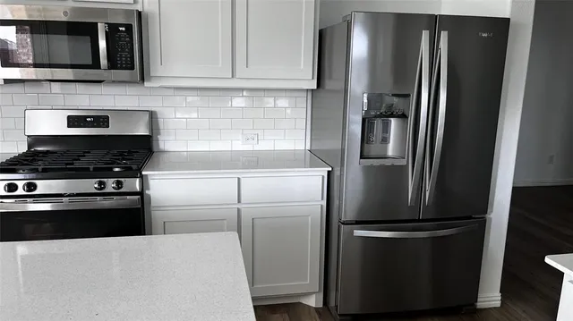a kitchen with stainless steel appliances a refrigerator stove and microwave