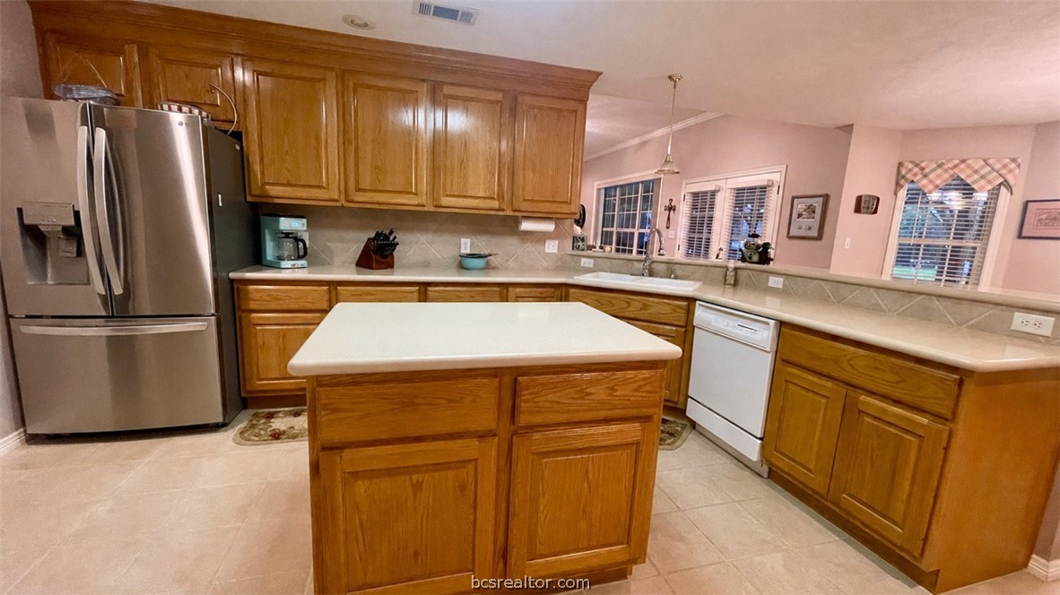 10432 Sammys Road Bremond, TX 76629 - Photo 11 of 47 a kitchen with stainless steel appliances granite countertop a refrigerator a sink dishwasher a stove with wooden cabinets