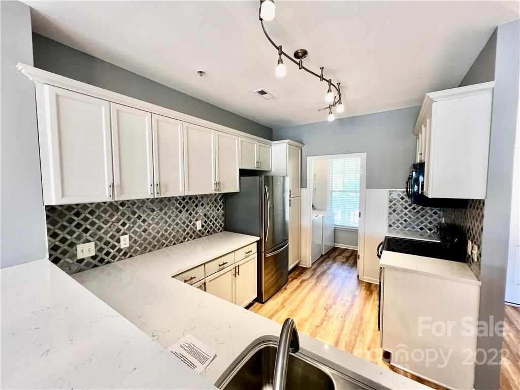 18742 Nautical Drive, Unit 305 Cornelius, NC 28031 - Photo 11 of 30 a kitchen with stainless steel appliances granite countertop a sink stove and refrigerator
