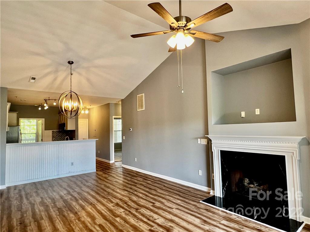 18742 Nautical Drive, Unit 305 Cornelius, NC 28031 - Photo 7 of 30 a view of a livingroom with a fireplace a chandelier fan and wooden floor