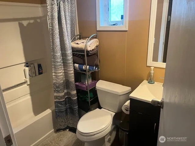 a white toilet sitting next to a bathroom sink and tub