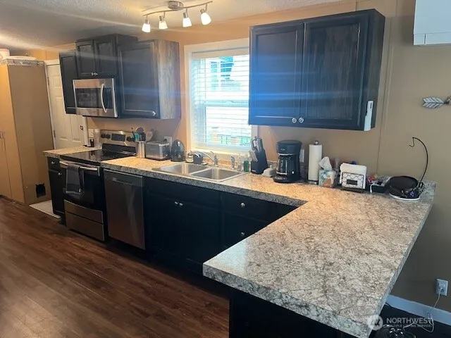 a kitchen with stainless steel appliances granite countertop a sink stove and cabinets