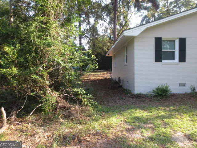 a backyard of a house with table and chairs