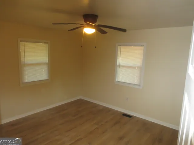 an empty room with a window and a fan