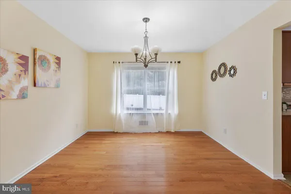 a view of a room with window wooden floor and front door