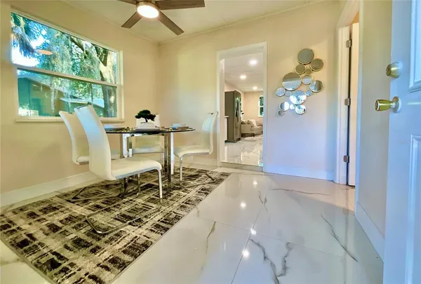 a view of a dining room with furniture a chandelier and wooden floor