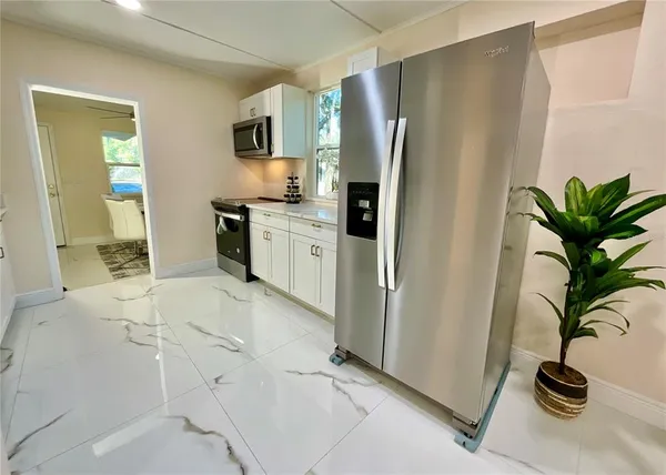 a kitchen with stainless steel appliances a refrigerator a sink a stove a washer dryer and cabinets