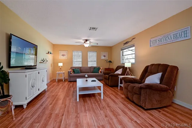 a living room with furniture and a wooden floor
