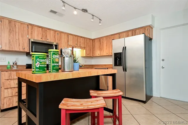 a kitchen with stainless steel appliances kitchen island granite countertop a sink a stove top oven a counter space and cabinets