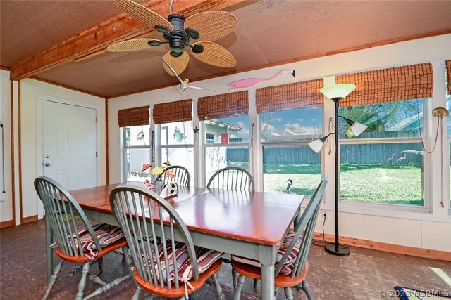 a view of a dining room with furniture large windows and wooden floor