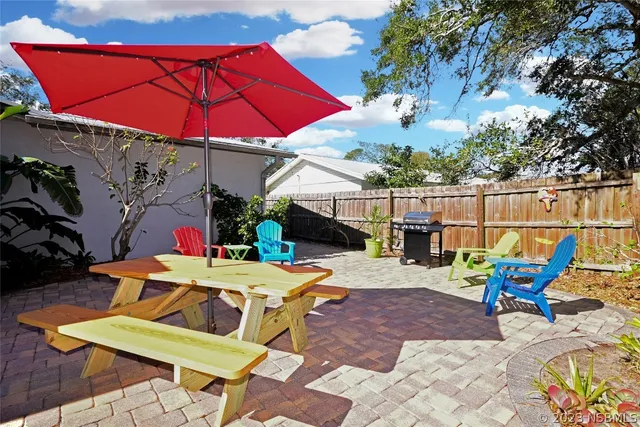a view of a house with pool and chairs next to a yard