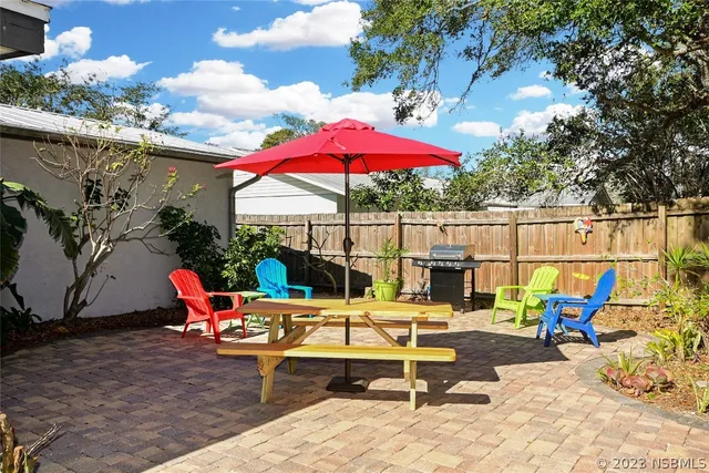 a view of a house with backyard and sitting area