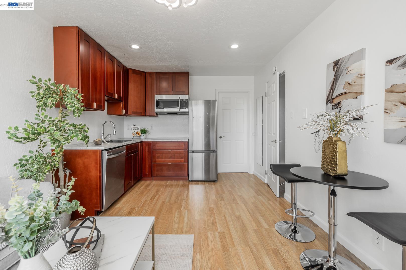 4032 Doane Street Fremont, CA 94538 - Photo 20 of 39 a kitchen with stainless steel appliances kitchen island granite countertop a table chairs in it and wooden floors