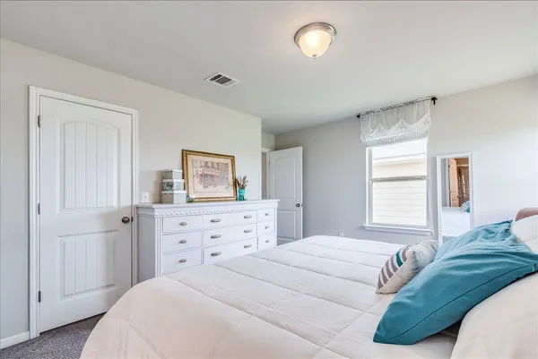 a bedroom with a bed and a dresser