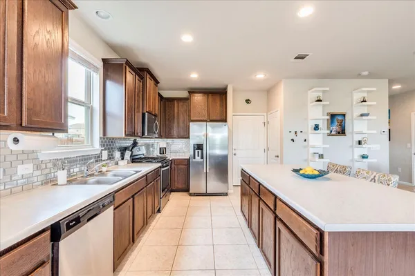 a kitchen with stainless steel appliances a sink stove and cabinets