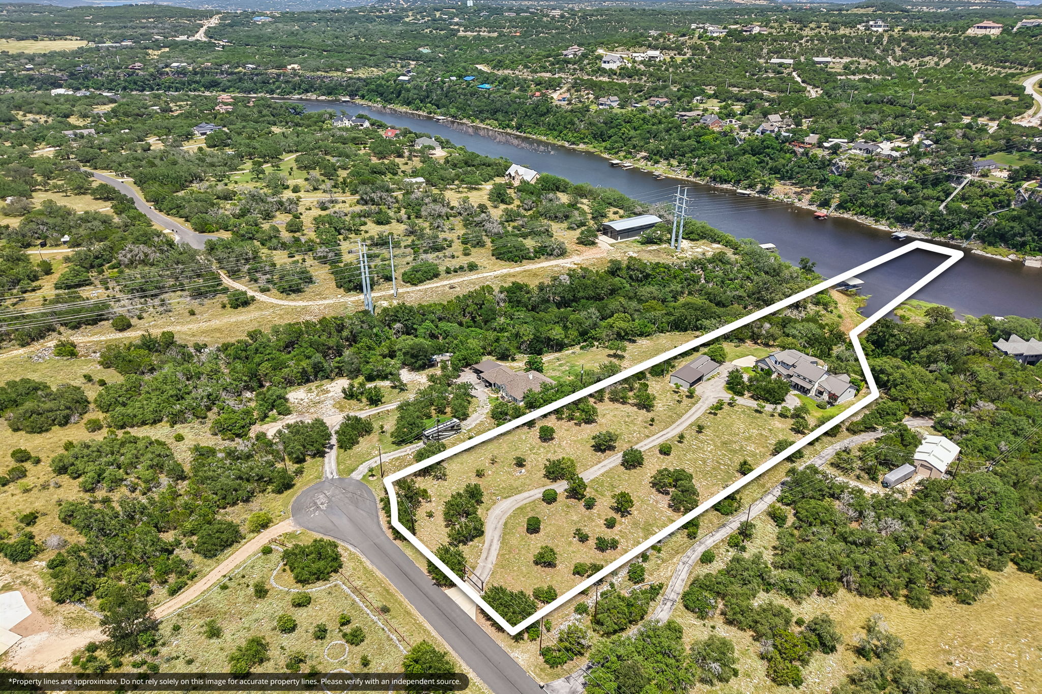 2203 Improver Road Spicewood, TX 78669 - Photo 2 of 38 A sprawling waterfront estate offers verdant grounds, direct lake access, and a private dock.