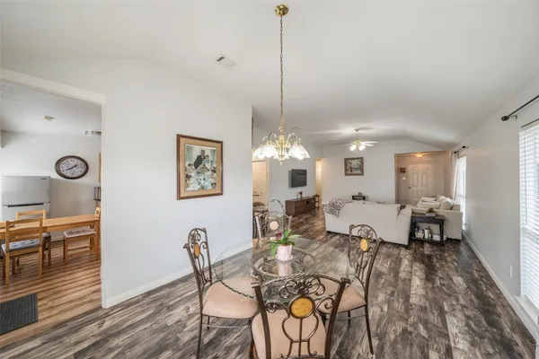 a living room with furniture a dining table and a chandelier