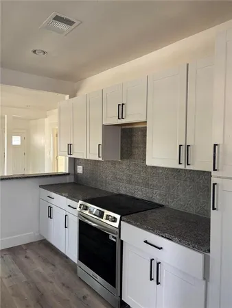 a kitchen with stainless steel appliances granite countertop a sink and a stove