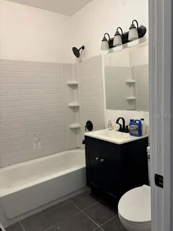 a bathroom with a bathtub sink vanity mirror and toilet