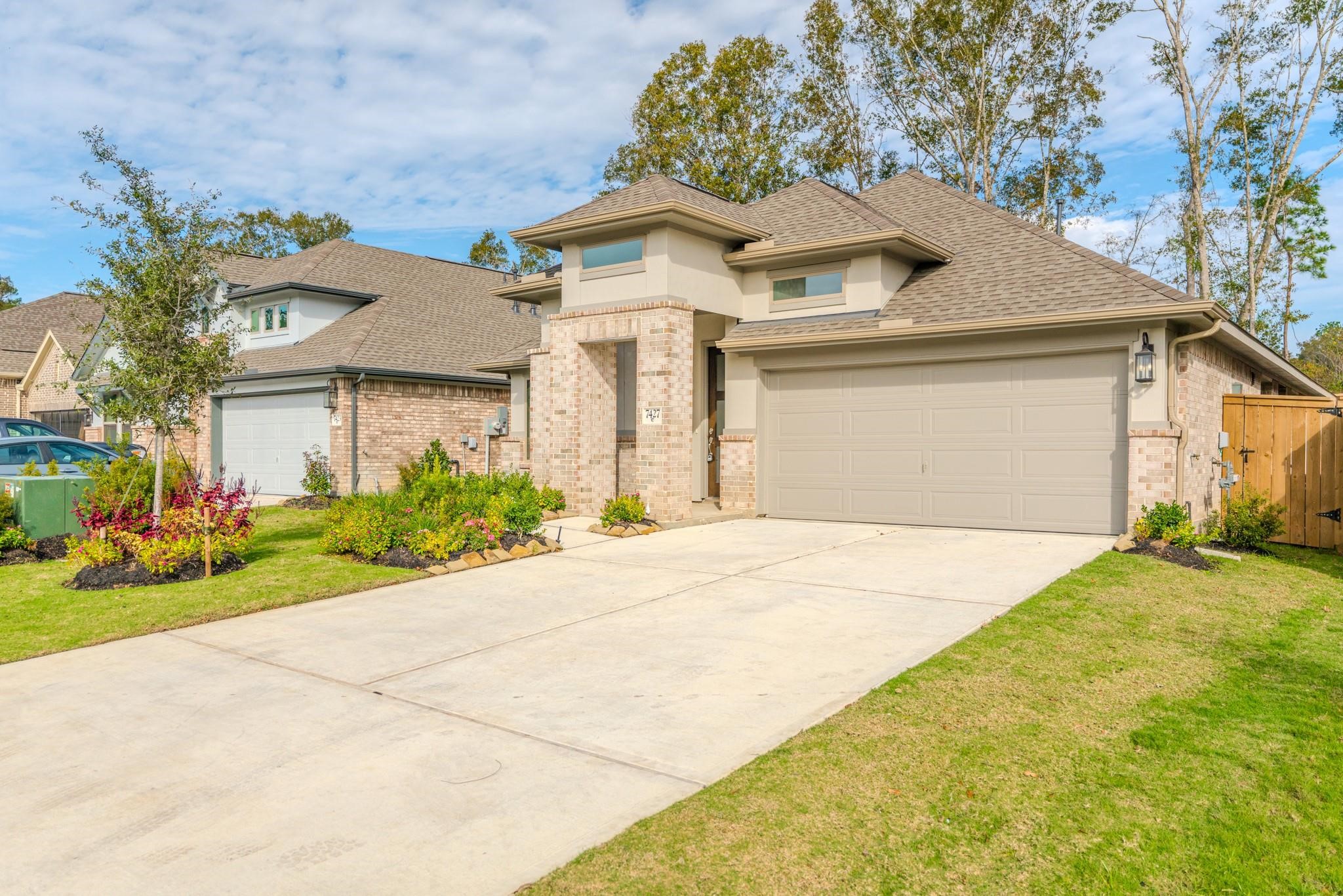 7427 Caprock Cyn Lane Porter, TX 77365 - Photo 1 of 21 a front view of a house with a yard and garage