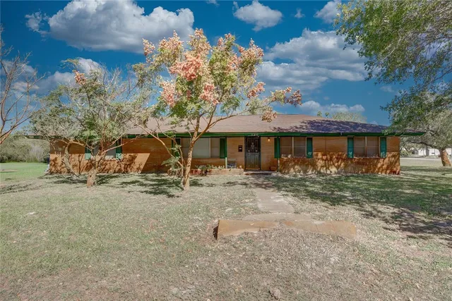 a view of a house with a yard and sitting area