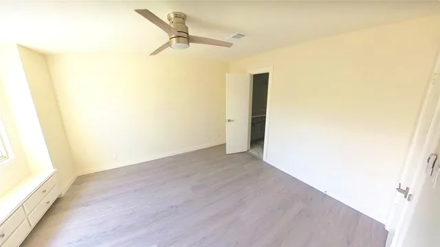 an empty room with wooden floor and a sink