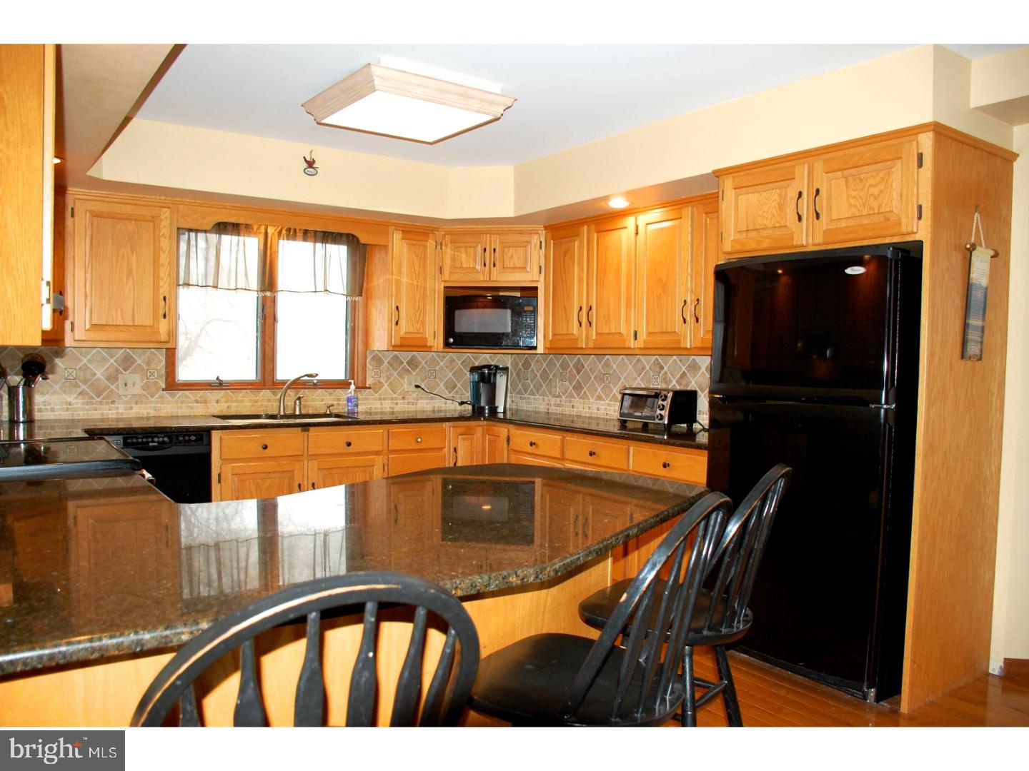163 Mail Rte Road Sinking Spring, PA 19608 - Photo 12 of 25 a kitchen with stainless steel appliances granite countertop a stove top oven a refrigerator a sink and a dining table with large window