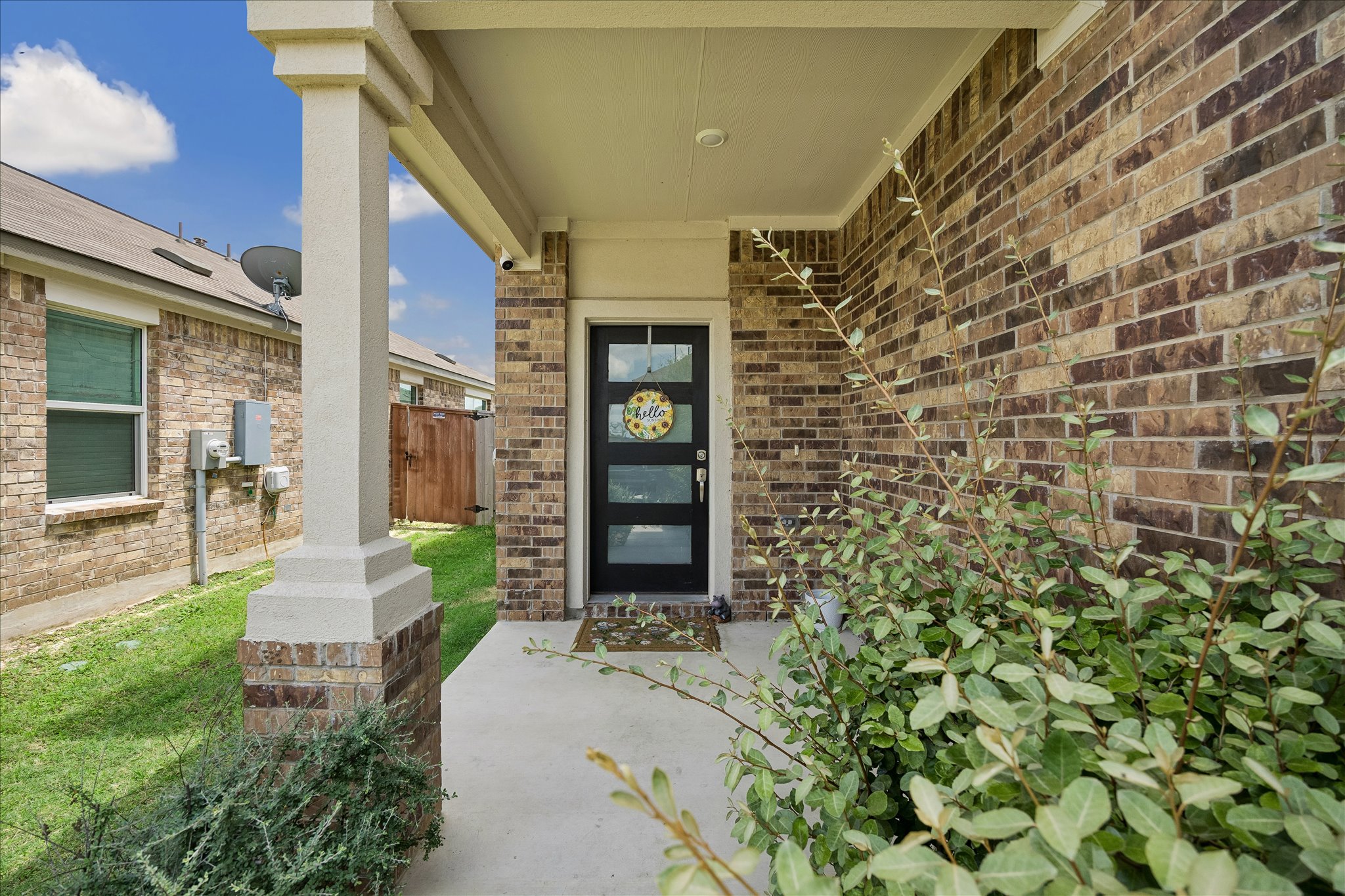 217 Canley Loop Hutto, TX 78634 - Photo 4 of 36 A welcoming brick facade with a modern black door invites you home.