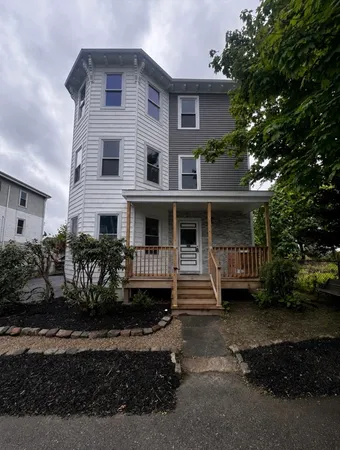 a view of house with yard and sitting area
