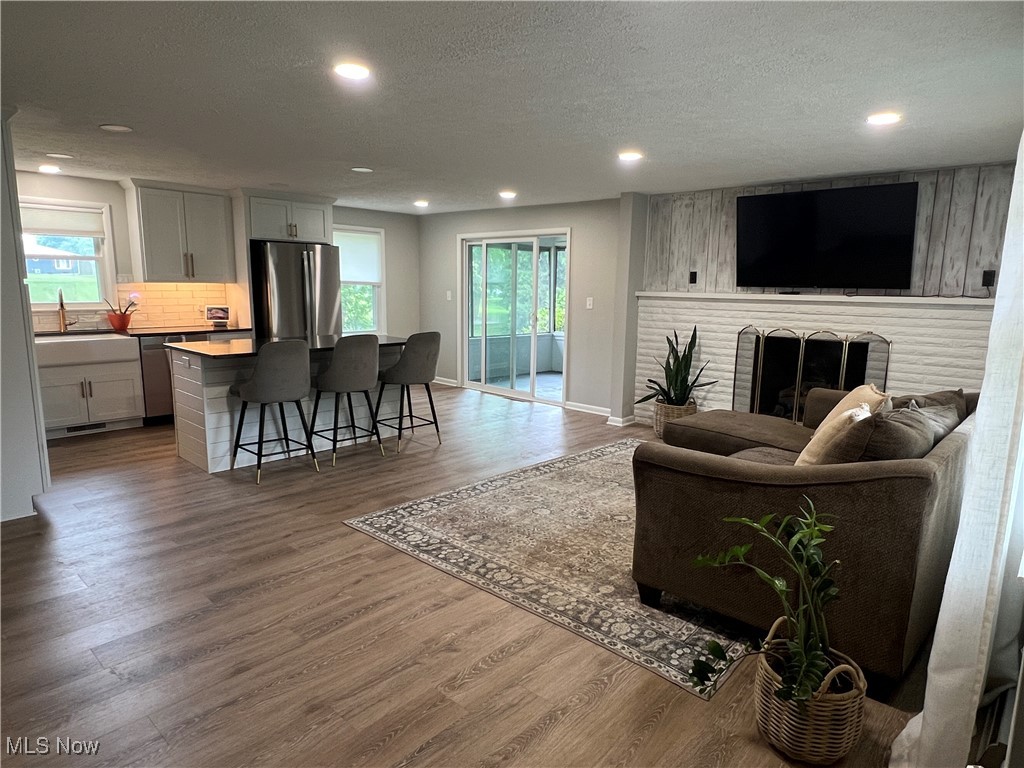 232 Hoffman Road Loudonville, OH 44842 - Photo 7 of 28 Living area with recessed lighting, wood finished floors, a textured ceiling, plenty of natural light, and a brick fireplace