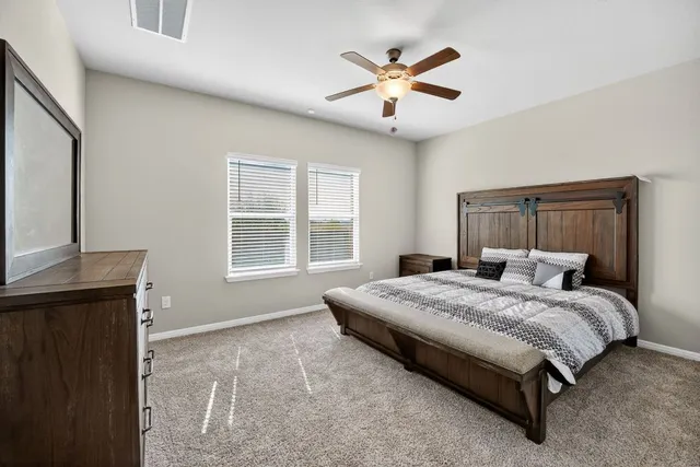 a spacious bedroom with a bed and a chandelier