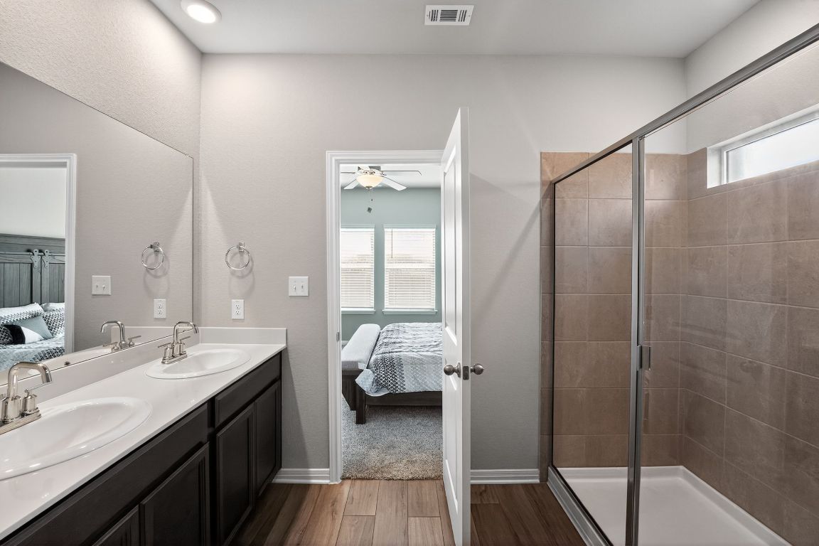 17801 Prairie Land Way Manor, TX 78653 - Photo 16 of 31 a en suite bathroom with a double vanity sink and a mirror