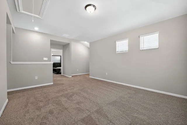 an empty room with closet and windows