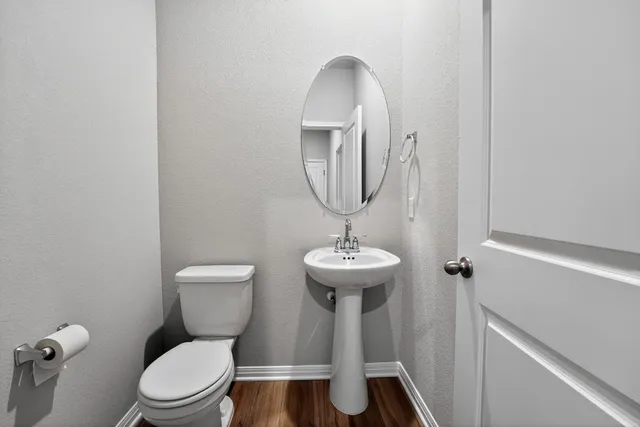 a bathroom with a toilet sink and mirror