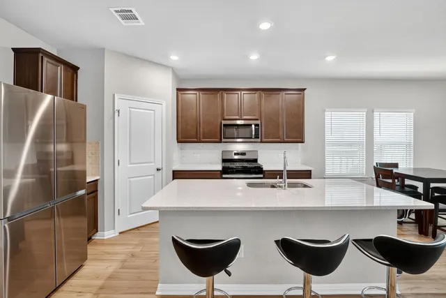 a kitchen with stainless steel appliances a refrigerator and microwave