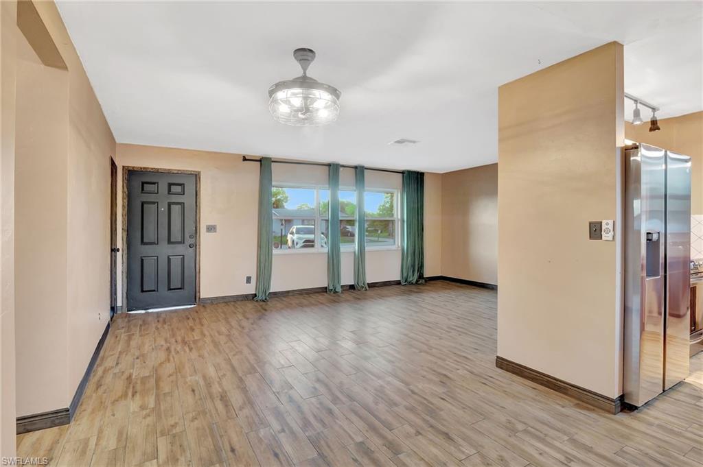 14 Illinois Road Lehigh Acres, FL 33936 - Photo 14 of 31 an empty room with wooden floor and windows
