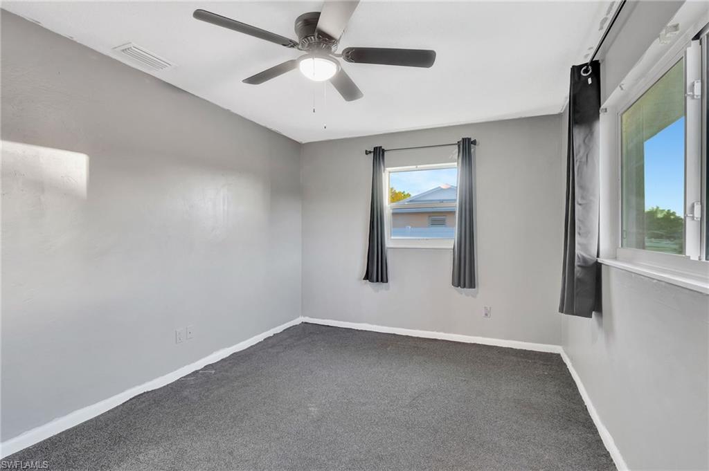 14 Illinois Road Lehigh Acres, FL 33936 - Photo 18 of 31 en empty room with windows and ceiling fan